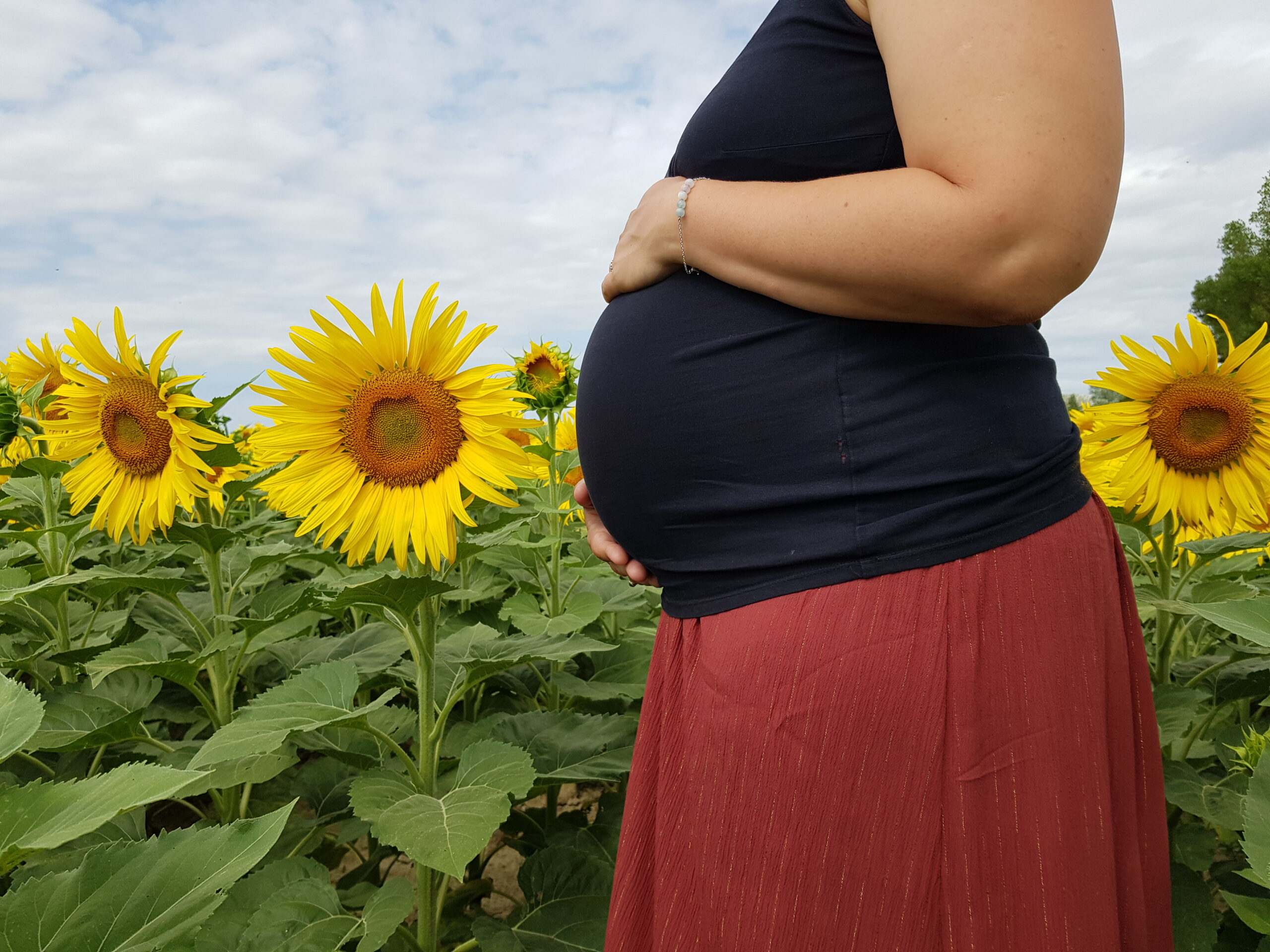 Une femme enceinte dans un champ de tournesol